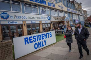 Pedestrians walk pas the Royal Seabank Hotel in Blackpool as Lancashire enters tier 3 of the government’s coronavirus alert system